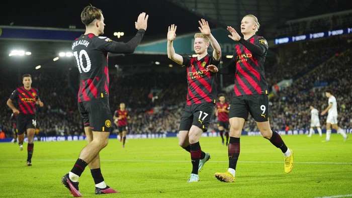 Manchester Citys Erling Haaland, right, celebrates with teammates Kevin De Bruyne, centre, and Jack Grealish after scoring his sides second goal during the English Premier League soccer match between Leeds United and Manchester City, at Elland Road Stadium in Leeds, England, Wednesday, Dec. 28, 2022. (AP Photo/Jon Super)