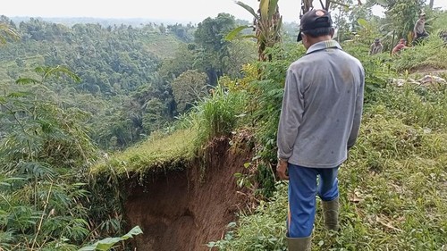 Warga memantau tanah tegalan yang amblas akibat hujan dan irigasi, Kamis (29/12/2022) siang.