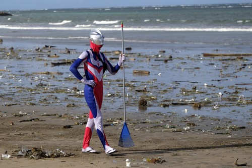 Warga negara Jepang Suzuki Hiromasa mengenakan kostum Ultraman saat membersihkan sampah di Pantai Kuta, Badung, Bali, Kamis (29/12/2022). Menjelang pergantian tahun baru 2023, sampah kiriman mulai berserakan di kawasan objek wisata tersebut akibat dampak cuaca ekstrem yang terjadi sejak Jumat (23/12). ANTARA FOTO/Nyoman Hendra Wibowo/rwa.