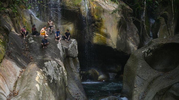 WISATA PETUALANGAN LUBUK NYARAI Pengunjung berenang di kolam Lubuk Nyarai, hutan Gamaran, Lubuk Alung, Kabupaten Padang Pariaman, Sumatera Barat, Rabu (28/12/2022). Wisata petualangan Lubuk Nyarai yang dapat ditempuh dengan treking sejauh 5,5 kilometer tersebut menyajikan air terjun dan kolam alami yang terbentuk oleh fenomena breksi atau pusaran air yang menggerus dinding kolam selama ribuan tahin, sehingga membuat kolam terus membesar. ANTARA FOTO/Iggoy el Fitra/foc.