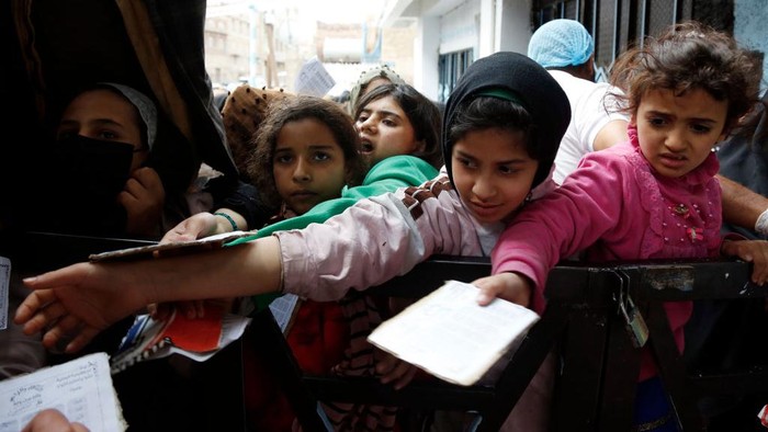 SANA'A, YEMEN - DECEMBER 29: Yemeni girls from families affected by war wait to receive free meals provided by a charitable kitchen on December 29, 2022 in Sana'a, Yemen. Following eight years of war, blockades, and an economic crisis in one of the world's poorest countries, around 19 million people are severely hungry struggling daily to obtain food, and potable water. With the world's celebration of entering the new 2023 year, an estimated 21.6 million people will need humanitarian assistance and protection services in Yemen. (Photo by Mohammed Hamoud/Getty Images)
