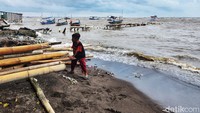 Meski cuaca ekstrem, anak ini justru asyik bermain di pinggir pantai.