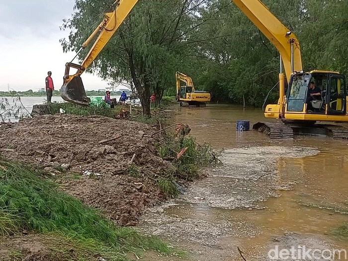 Dua alat berat dikerahkan untuk menutup tanggul jebol di kawasan Pantai Marina Semarang, Jumat (30/12/2022).