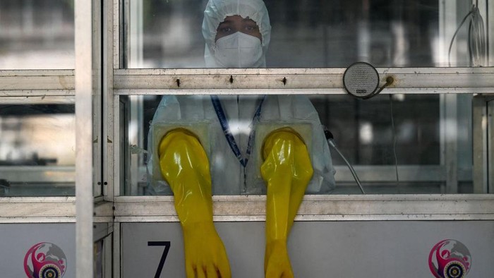 TOPSHOT - A health worker wearing personal protective equipment (PPE) stands inside a swab collection booth to check preparation of Covid-19 test facilities at a hospital in Mumbai on December 27, 2022. (Photo by Punit PARANJPE / AFP) (Photo by PUNIT PARANJPE/AFP via Getty Images)