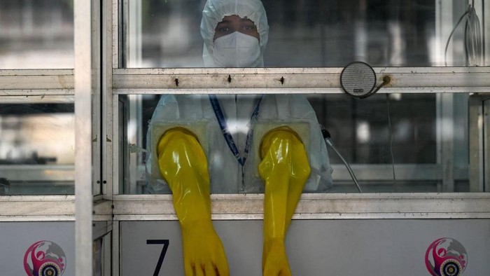 India Gelar Latihan Siaga Tsunami COVID-19 TOPSHOT - A health worker wearing personal protective equipment (PPE) stands inside a swab collection booth to check preparation of Covid-19 test facilities at a hospital in Mumbai on December 27, 2022. (Photo by Punit PARANJPE / AFP) (Photo by PUNIT PARANJPE/AFP via Getty Images)