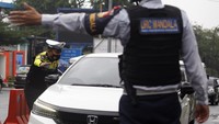 Petugas Sat Lantas Polres Bogor dan petugas Dishub Kabupaten Bogor mengarahkan kendaraan wisatawan pada penyekatan kendaraan nomor polisi ganjil genap di jalur wisata Puncak, Gadog, Kabupaten Bogor, Jawa Barat, Jumat (30/12/2022).