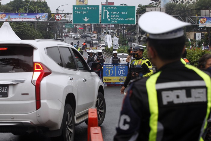Petugas Sat Lantas Polres Bogor dan petugas Dishub Kabupaten Bogor mengarahkan kendaraan wisatawan saat penyekatan kendaraan nomor polisi ganjil genap di jalur wisata Puncak, Gadog, Kabupaten Bogor, Jawa Barat, Jumat (30/12/2022). Polres Bogor berencana menutup total jalur wisata Puncak guna meminimalisir pergerakan orang pada malam pergantian Tahun Baru 2023 mulai tanggal (31/12/2022) pukul 18.00 WIB hingga tanggal (1/1/2023) pukul 06.00 WIB . ANTARA FOTO/Yulius Satria Wijaya/rwa.