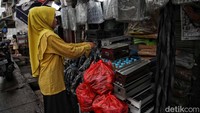 Seorang pedagang merapikan barang dagangannya di kawasan Cilincing, Jakarta Utara, Kamis (29/12/2022).