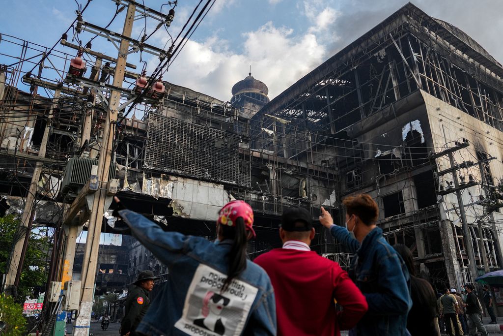 Cambodian police officers ride a motorcycle past the Grand Diamond City hotel-casino, as Thai and Cambodian rescuers struggle to extricate dozens of people feared trapped after a fire broke, killing at least 10 and injuring dozens in Poipet near Thailand border, Cambodia, December 29, 2022. REUTERS/Athit Perawongmetha     TPX IMAGES OF THE DAY