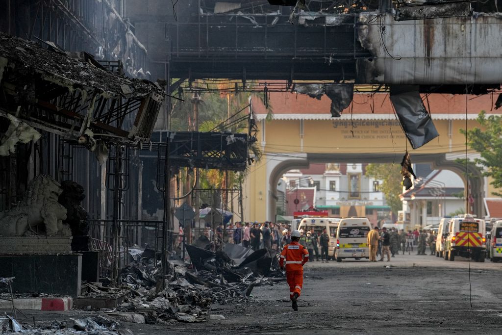 Cambodian police officers ride a motorcycle past the Grand Diamond City hotel-casino, as Thai and Cambodian rescuers struggle to extricate dozens of people feared trapped after a fire broke, killing at least 10 and injuring dozens in Poipet near Thailand border, Cambodia, December 29, 2022. REUTERS/Athit Perawongmetha     TPX IMAGES OF THE DAY