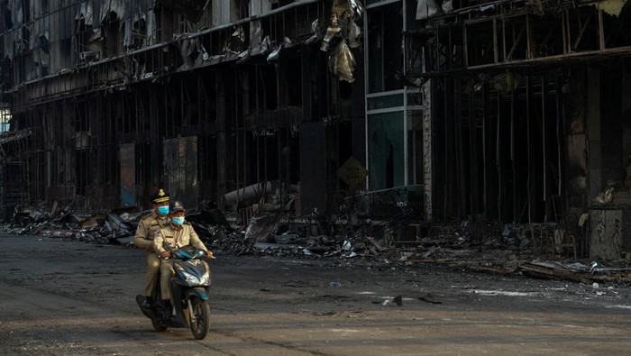 Kasino di Kamboja Terbakar, 19 Orang Tewas Cambodian police officers ride a motorcycle past the Grand Diamond City hotel-casino, as Thai and Cambodian rescuers struggle to extricate dozens of people feared trapped after a fire broke, killing at least 10 and injuring dozens in Poipet near Thailand border, Cambodia, December 29, 2022. REUTERS/Athit Perawongmetha TPX IMAGES OF THE DAY