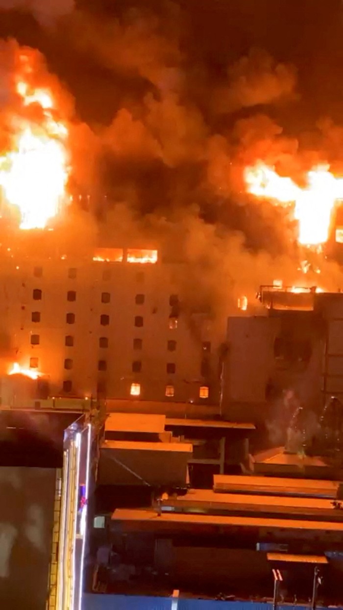Kasino di Kamboja Terbakar, 19 Orang Tewas Cambodian police officers ride a motorcycle past the Grand Diamond City hotel-casino, as Thai and Cambodian rescuers struggle to extricate dozens of people feared trapped after a fire broke, killing at least 10 and injuring dozens in Poipet near Thailand border, Cambodia, December 29, 2022. REUTERS/Athit Perawongmetha TPX IMAGES OF THE DAY