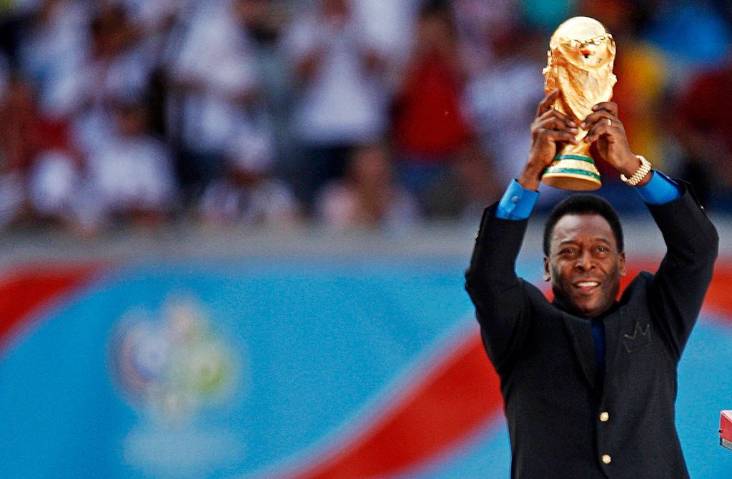 Legenda sepak bola Brasil dan anggota tim sepak bola Brasil pemenang Piala Dunia 1958, 1962 dan 1970 Pele memegang trofi Piala Dunia saat upacara pembukaan Piala Dunia 2006 di Munich, Jerman, 9 Juni 2006. (REUTERS/DYLAN MARTINEZ)