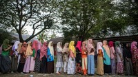 Migran Rohingya antre untuk mendapatkan bantuan di lokasi penampungan sementara di SMP Negeri 2 Curei, Gampong Curei, Kecamatan Muara Tiga, Kabupaten Pidie, Aceh, Kamis (29/12/2022).