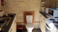 Dapur ini malah dirancang dengan kloset toilet di tengahnya. Bagaimana ya aroma masakan tercampur dengan toilet?