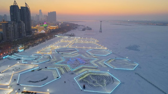 Sungai Beku di China Berhias Lampu LED Bentuk Kepingan Salju HARBIN, CHINA - DECEMBER 29: LED light strips forming in the shape of snowflake are illuminated during the 5th Songhua River Ice and Snow Carnival on December 29, 2022 in Harbin, Heilongjiang Province of China. (Photo by VCG/VCG via Getty Images)
