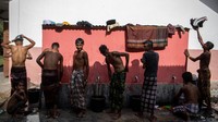 Tampak sejumlah pengungsi Rohingya laki-laki mandi di keran luar kamar mandi.  