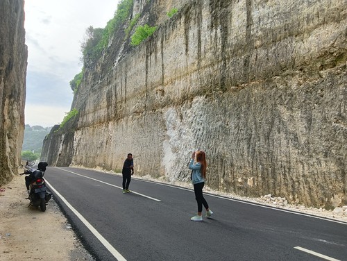 Wisatawan berfoto di tebing Pantai Tanah Barak, Badung, Bali, Jumat (30/12/2022).