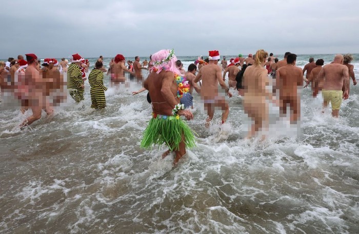 EDITORS NOTE: Graphic content / People take part in a traditional sea bath to mark the New Years celebrations on a nudist beach in Le Cap dAgde, southern France, on December 31, 2022. (Photo by Pascal GUYOT / AFP) (Photo by PASCAL GUYOT/AFP via Getty Images)