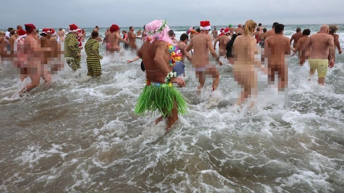 1245897881 EDITORS NOTE: Graphic content / People take part in a traditional sea bath to mark the New Year's celebrations on a nudist beach in Le Cap d'Agde, southern France, on December 31, 2022. (Photo by Pascal GUYOT / AFP) (Photo by PASCAL GUYOT/AFP via Getty Images)