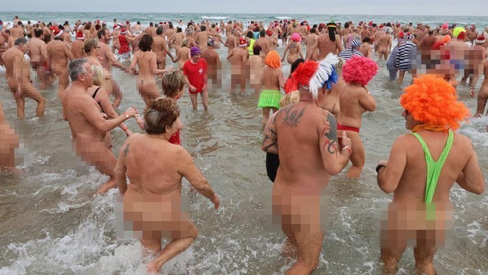 EDITORS NOTE: Graphic content / People take part in a traditional sea bath to mark the New Year's celebrations on a nudist beach in Le Cap d'Agde, southern France, on December 31, 2022. (Photo by Pascal GUYOT / AFP) (Photo by PASCAL GUYOT/AFP via Getty Images)
