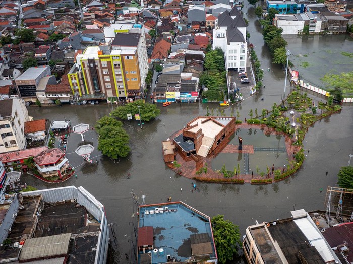 Warga mendorong sepeda motornya yang mogok di jalan yang terendam banjir di Kawasan Cagar Budaya Nasional Kota Lama Semarang, Jawa Tengah, Sabtu (31/12/2021). Sejumlah jalan di kawasan cagar budaya nasional dengan julukan Little Netherland yang dibangun pada masa pemerintahan Kolonial Belanda sekitar abad ke-18 itu terendam banjir dengan ketinggian bervariasi antara sekitar 20-60 cm akibat intensitas hujan tinggi sejak Sabtu (31/12) dini hari. ANTARA FOTO/Aji Styawan/aww.