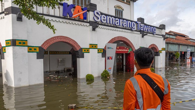 Petugas stasiun memindahkan kursi tunggu penumpang yang terendam banjir di selasar tunggu Stasiun Tawang, Semarang, Jawa Tengah, Sabtu (31/12/2022). Banjir yang merendam stasiun dengan ketinggian air bervariasi 15-70 cm akibat intensitas hujan tinggi sejak Sabtu (31/12) dini hari itu menyebabkan sejumlah aktivitas pelayanan stasiun terganggu serta sejumlah rute perjalanan kereta api mengalami keterlambatan baik kedatangan maupun keberangkatan. ANTARA FOTO/Aji Styawan/aww.