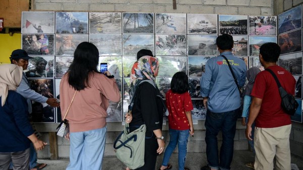 Sejumlah wisatawan mengamati foto-foto letusan Gunung Merapi yang terjadi pada 26 Oktober 2010.