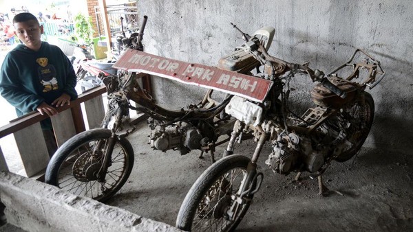 Seorang anak laki-laki melihat rongsokan sepeda motor akibat letusan Gunung Merapi 2010.