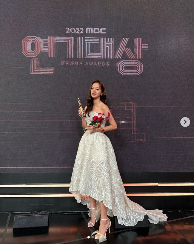 Personel Girl’s Day, Hyeri memakai gaun putih berpotongan asimetris dengan detail sulaman dari rumah mode lokal Bridal Kong. Berkat penampilannya dalam drama Korea May I Help You, Hyeri memenangkan penghargaan Excellence Award. Foto: Instagram
