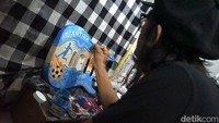 Tommy mendapatkan orderan dari customer untuk melukis gitar dengan tema tim sepakbola Argentina’ .