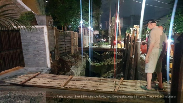 Jalan ambrol di Pakis Argosari Surabaya sedang dilakukan perbaikan dan dibuatkan jembatan untuk pemilik rumah.