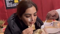 Menikmati sejenis gorengan dengan isian keju lumer, Ashanty tampak sangat bahagia nih! Ia mencicipi makanan ini bersama-sama.