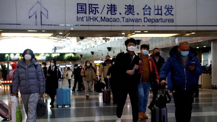 FILE PHOTO: Travellers walk with their luggage at Beijing Capital International Airport, amid the coronavirus disease (COVID-19) outbreak in Beijing, China December 27, 2022. REUTERS/Tingshu Wang/File Photo/File Photo