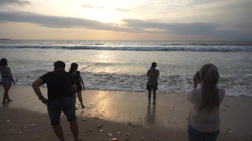 Pengunjung Pantai Kuta mengabadikan momen detik-detik matahari terakhir di 2022, Sabtu (31/12/2022). (Agus Eka)