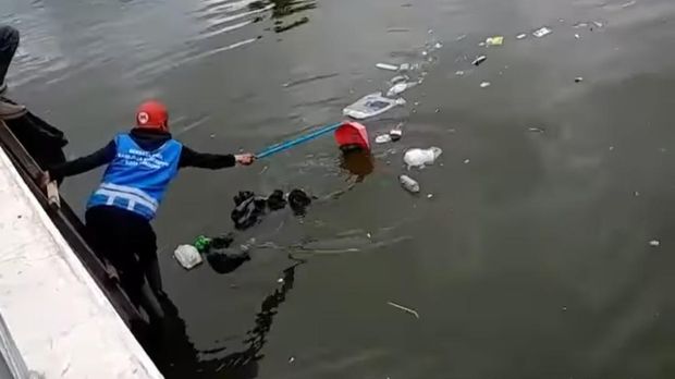 Petugas membersihka sampah di sekitar Masjid Al Jabbar