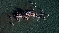 Sebuah gambar drone menunjukkan jamaah membawa Mikoshi atau kuil portabel di laut selama festival untuk mengharapkan air laut yang tenang dan keberuntungan di tahun baru, di Oiso, prefektur Kanagawa, sebelah barat Tokyo, Jepang, 1 Januari 2023.