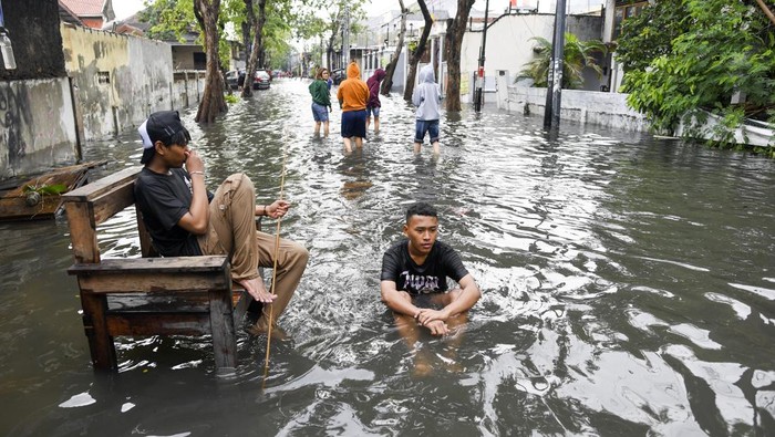 Petugas Penanganan Prasarana & Sarana Umum (PPSU) menjaring sampah saat terjadinya banjir di kawasan Semper Barat, Jakarta Utara, Minggu (1/1/2023).  Intensitas hujan yang tinggi serta kurangnya kesadaran warga dalam membuang sampah pada tempatnya membuat sejumlah wilayah di Jakarta Utara terendam banjir. ANTARA FOTO/M Risyal Hidayat/rwa.
