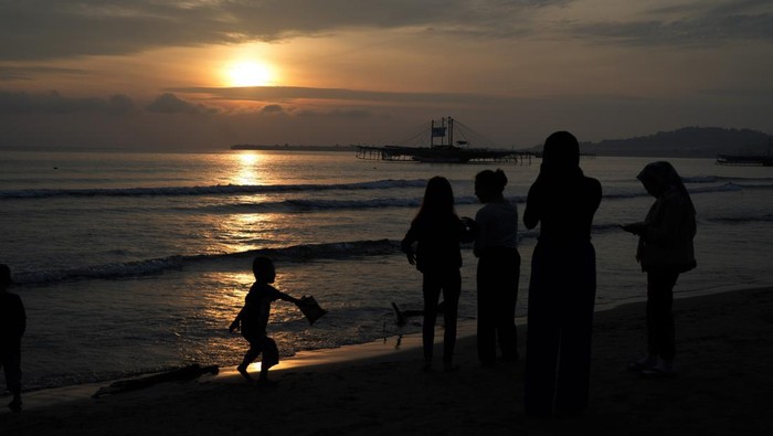 Wisatawan bermain air di objek wisata Pantai Taipa, Kabupaten Konawe Utara, Sulawesi Tenggara, Minggu (1/1/2023). Pantai Taipa yang menghadap di Laut Banda merupakan destinasi wisata bahari unggulan Konawe Utara dengan daya tarik keindahan alam dan hamparan pasir putihnya. ANTARA FOTO/Jojon.