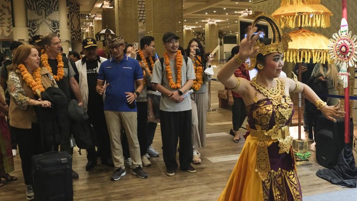 KEDATANGAN PENUMPANG PESAWAT INTERNASIONAL PERTAMA Menteri Pariwisata dan Ekonomi Kreatif (Menparekraf) Sandiaga Salahuddin Uno (kanan) berbincang dengan penumpang pesawat yang tiba pertama di Terminal Kedatangan Internasional pada pergantian Tahun Baru 2023 di Bandara I Gusti Ngurah Rai, Badung, Bali, Minggu (1/1/2023). Sebanyak 273 penumpang pesawat Korean Air yang terbang dari Bandara Internasional Incheon, Korea Selatan tersebut tiba pertama di Bandara I Gusti Ngurah Rai pada Tahun Baru 2023. ANTARA FOTO/Nyoman Hendra Wibowo/tom.