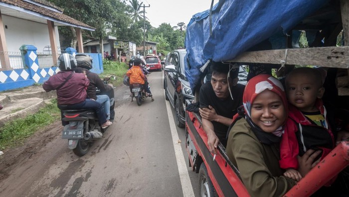 KEPADATAN JALUR WISATA ANYER SAAT LIBUR TAHUN BARU Sejumlah pengunjung menumpang kendaraan bak terbuka saat terjebak kemacetan di jalur Mancak-Anyer di Kabupaten Serang, Banten, Minggu (1/1/2023). Pada libur Tahun Baru 2023, arus lalu lintas menuju kawasan wisata Pantai Anyer, Carita, dan Kawasan Ekonomi Khusus (KEK) Tanjung Lesung terpantau padat antrean sekitar lebih dari dua kilometer. ANTARA FOTO/Muhammad Bagus Khoirunas/rwa.