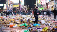 Polisi berjalan antara sampah yang berserakan.