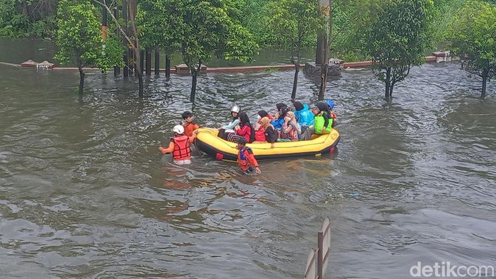 Relawan mengevakuasi warga terdampak banjir di Jalan Kaligawe, Semarang, Minggu (1/1/2023).