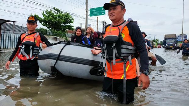 Tim SAR mengevakuasi warga yang kebanjiran di Semarang, Minggu (1/1/2023).