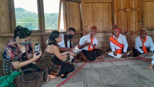 Wisatawan menerima seekor ayam dari tetua adat dalam ritual manuk kapu penyambutan tamu di mbaru gendang.