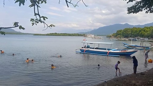 Wisatawan menikmati suasana Teluk Gilimanuk di Kelurahan Gilimanuk, Kecamatan Melaya, Kabupaten Jembrana, Bali, Minggu (1/1/2023).