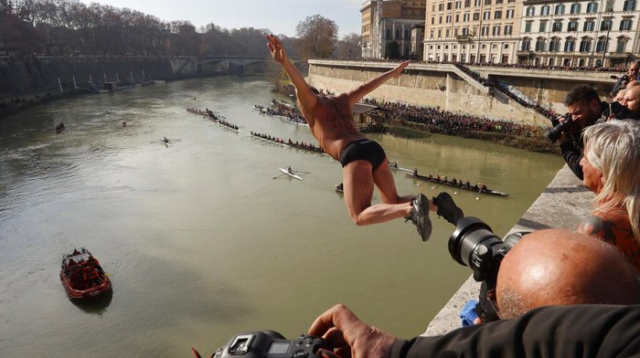 Aksi Warga Italia Lompat dari Ketinggian 18 Meter untuk Rayakan Tahun Baru Marco Fois, of Italy, dives into the Tiber river from the 18 meter (59 feet) high Cavour Bridge to celebrate the New Year Day in Rome, Sunday, Jan. 1, 2023. (AP Photo/Riccardo De Luca)