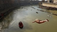 Puluhan orang ini melompat dari Jembatan Cavour setinggi 18 meter (59 kaki) untuk berenang di sungai Tiber.