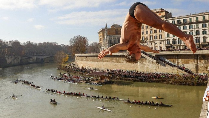 Marco Fois, of Italy, dives into the Tiber river from the 18 meter (59 feet) high Cavour Bridge to celebrate the New Year Day in Rome, Sunday, Jan. 1, 2023. (AP Photo/Riccardo De Luca)