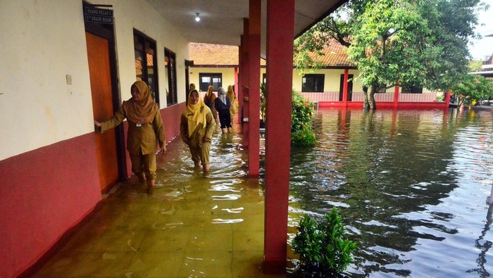 Guru mengecek kondisi sekolah yang terdampak banjir di SDN 3 Jati, Kudus, Jawa Tengah, Senin (2/1/2023). Sebanyak empat Sekolah Dasar Negeri (SD N) di kecamatan tersebut terdampak banjir sehingga aktivitas belajar mengajar diliburkan atau belajar di rumah.